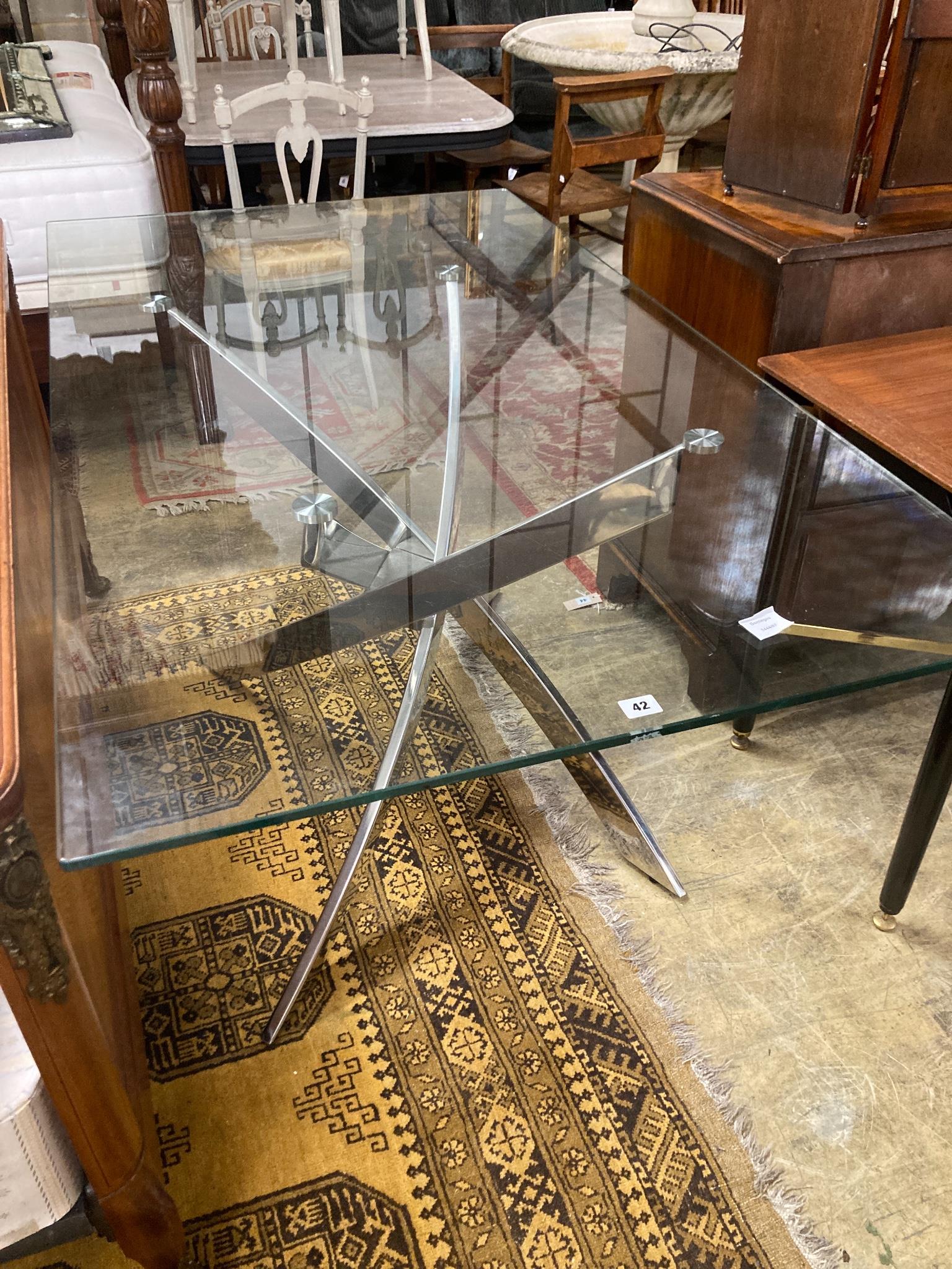 A modern plate glass topped dining table, with a stainless steel underframe, W.160cm D.90cm H.77cm
